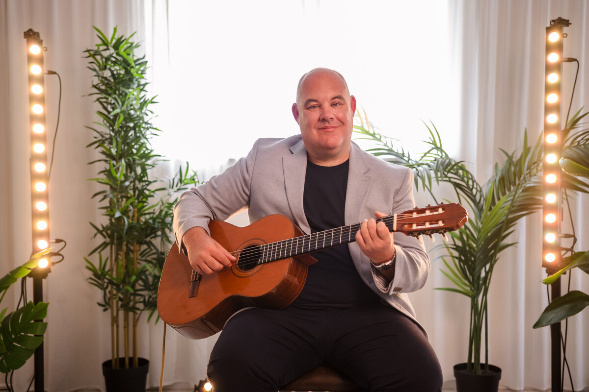 Wedding guitarist Stuart Toogood seated with his classical guitar