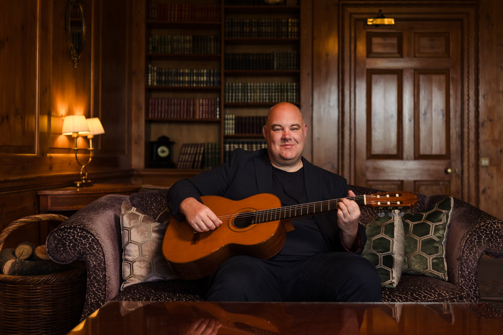 Stuart Toogood, professional wedding guitarist, seated with his acoustic guitar
