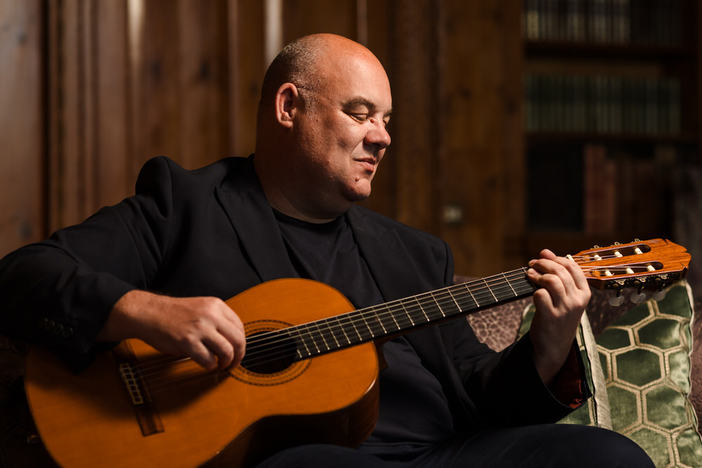Stuart Toogood playing acoustic guitar at a wedding ceremony
